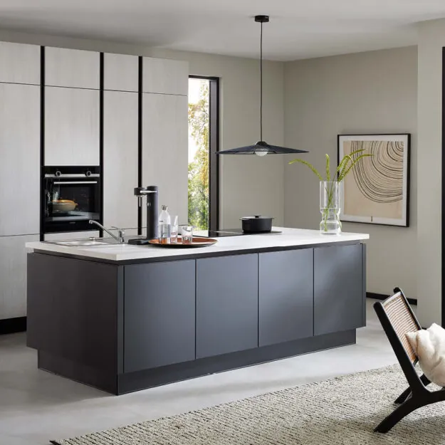 Moderne Burger Küche bei Küchenstudio Depping mit großer Kochinsel in dunklem Design, integriertem Kochfeld und minimalistischer Wohnküche