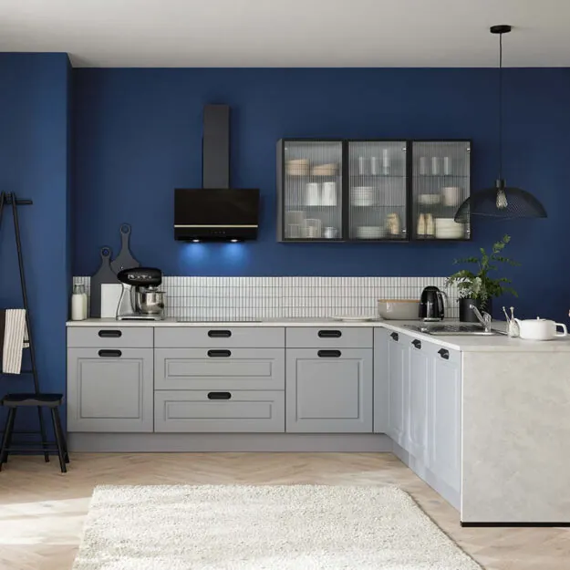 Moderne Burger Küche mit grauen Fronten und blauer Akzentwand, L-förmige Küchenzeile mit schwarzer Dunstabzugshaube und dekorativen Glasoberschränken