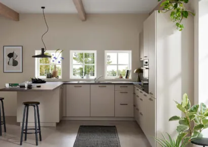 Helle Burger Küche in warmen Beigetönen mit L-förmiger Küchenzeile, Thekenbereich mit Hocker und großen Fenstern für viel Tageslicht